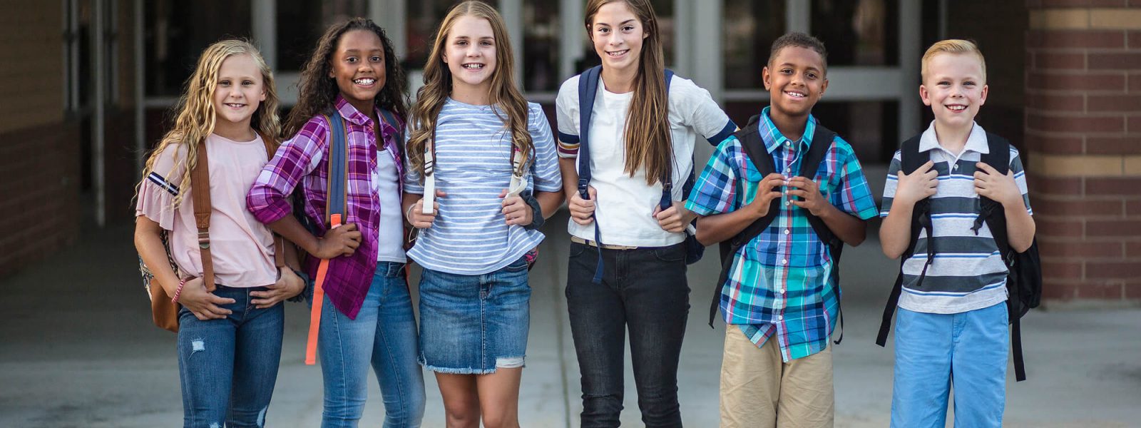 A diverse group of smiling tweens standing together, illustrating the social and emotional journey of parenting tweens.