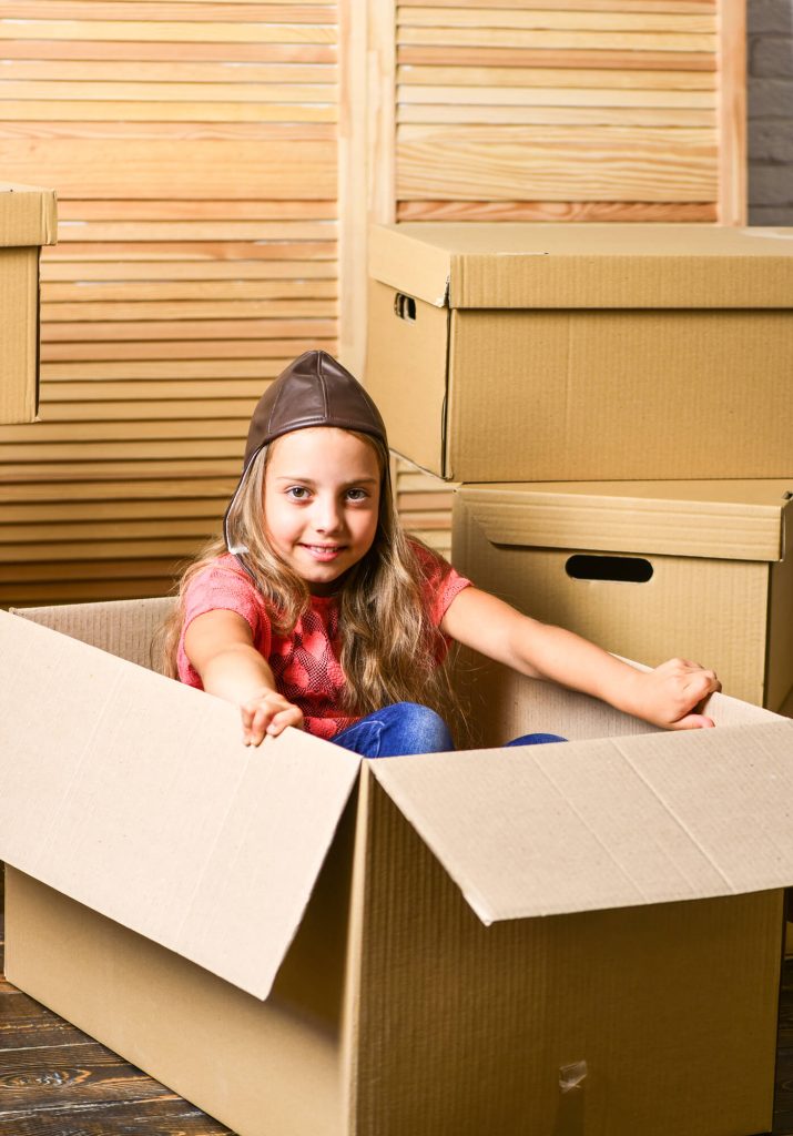 girl playing with cardboard box
