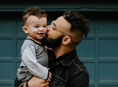 a father holding a toddler 