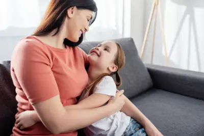 mom and daughter hugging mom hugging daughter on a sofa